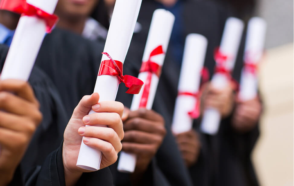  image of diplomas in the hands of graduates